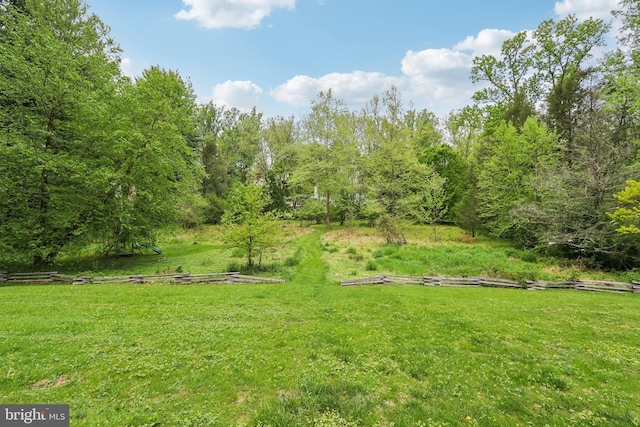 view of grassy yard with a rural view