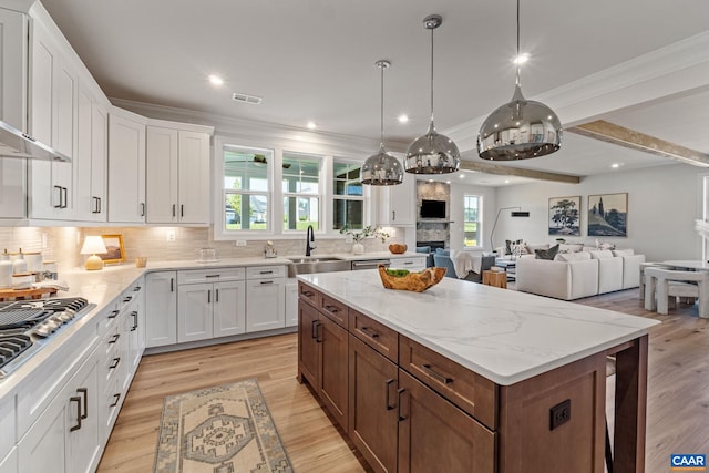 13A Sablewood Dr, Charlottesville, VA 22911 - kitchen with stainless steel gas cooktop, white cabinets, light wood-style flooring, and a kitchen island
