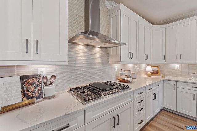 13A Sablewood Dr, Charlottesville, VA 22911 - kitchen with tasteful backsplash, stainless steel gas stovetop, light wood finished floors, wall chimney range hood, and white cabinets