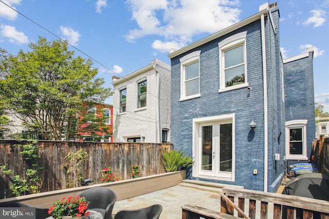 back of house featuring a fenced backyard and french doors