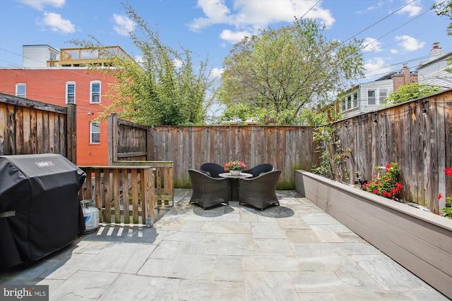 view of patio featuring a fenced backyard, area for grilling, and outdoor dining area