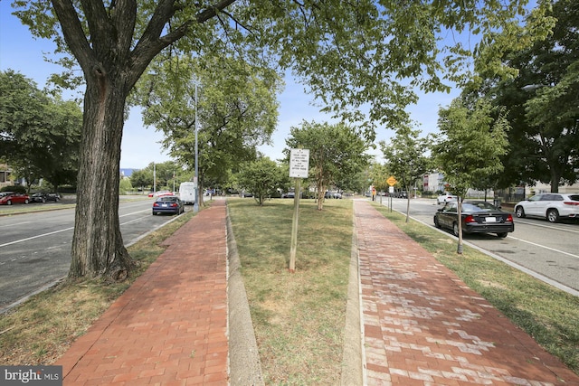 view of road featuring traffic signs, sidewalks, and curbs