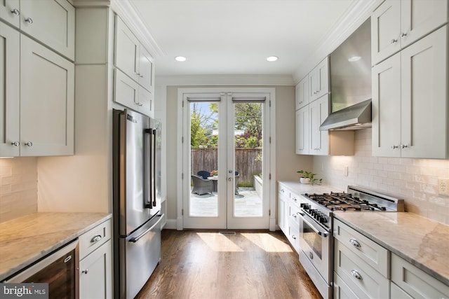 kitchen with recessed lighting, dark wood-style flooring, premium appliances, french doors, and beverage cooler