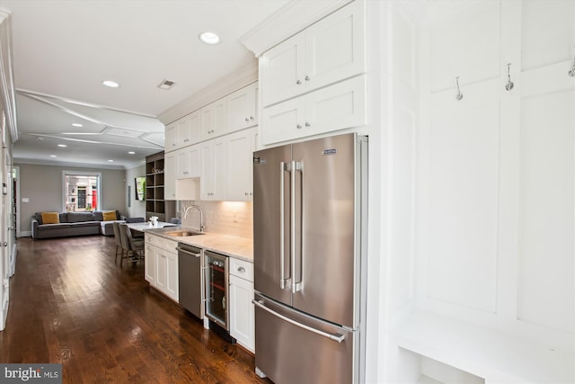 kitchen with a sink, stainless steel appliances, open floor plan, recessed lighting, and wine cooler