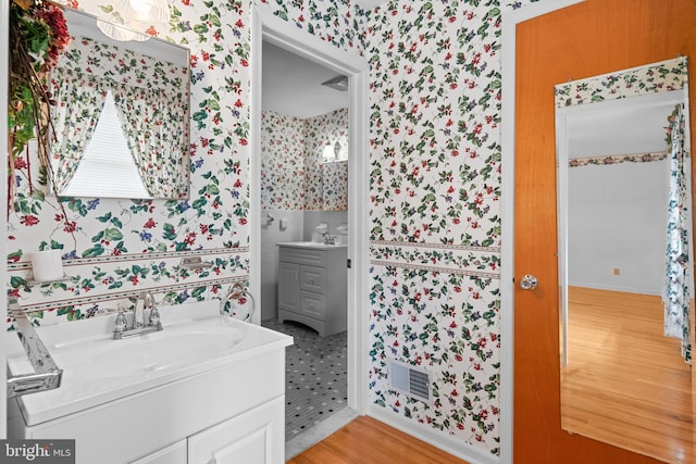 30 Stardust Dr, Newark, DE 19702 - bathroom featuring wallpapered walls, vanity, and wood finished floors