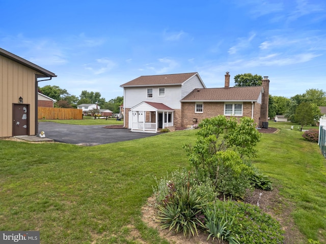 30 Stardust Dr, Newark, DE 19702 - rear view of house featuring a chimney, asphalt driveway, and brick siding