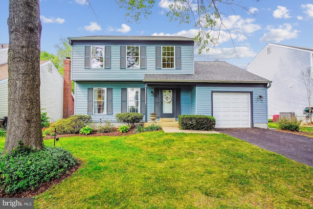 view of front of property featuring driveway, a front lawn, and a garage