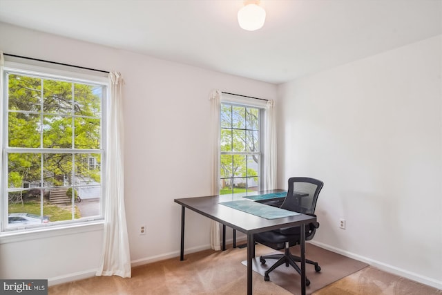 office space with baseboards and light colored carpet