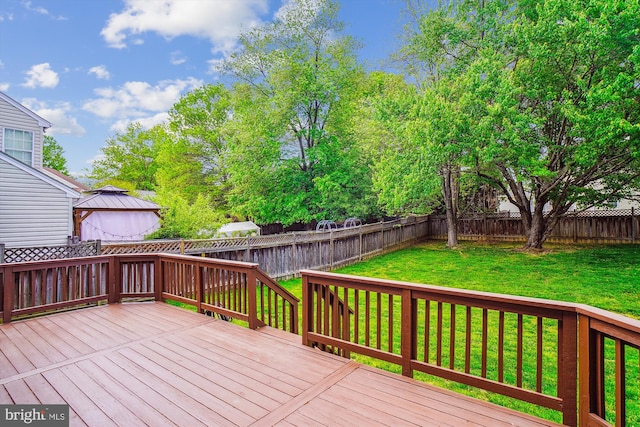 wooden terrace with a fenced backyard, a gazebo, and a yard