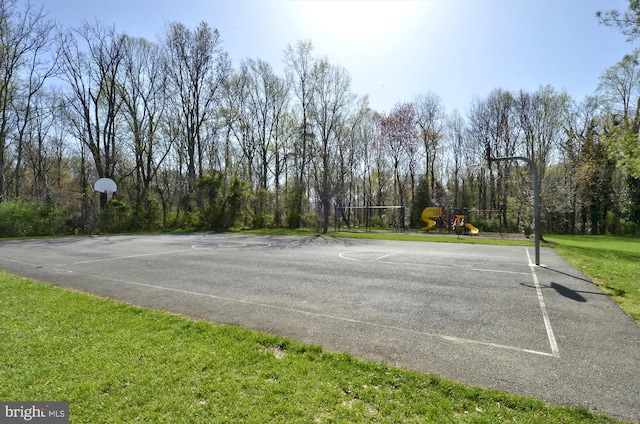 view of sport court featuring a yard, community basketball court, and playground community