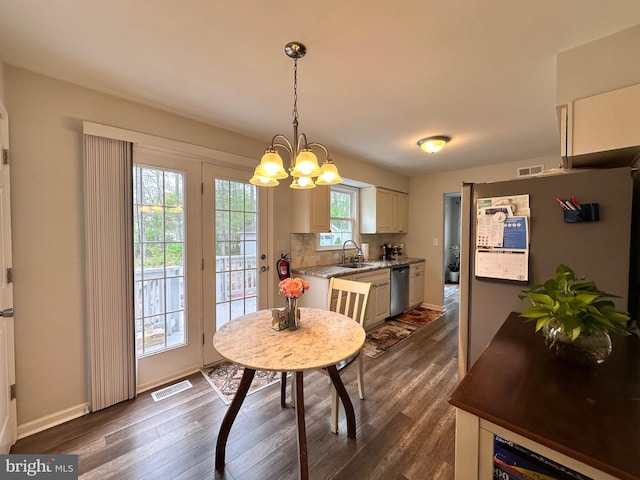dining area featuring visible vents, a notable chandelier, dark wood-style floors, and baseboards