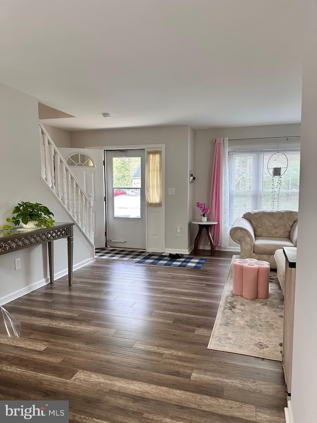 foyer entrance featuring stairway, wood finished floors, and baseboards