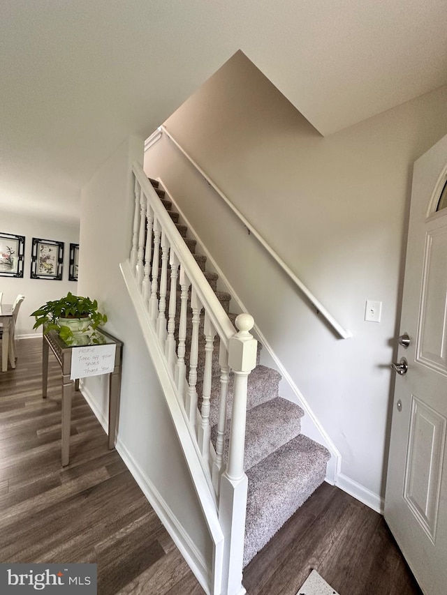stairway with wood finished floors and baseboards