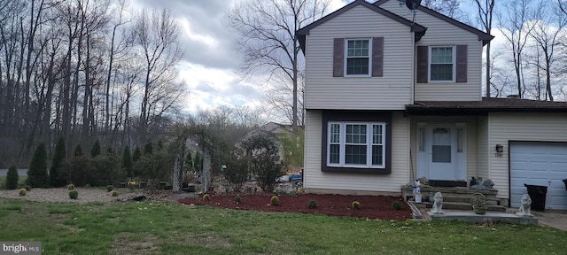 view of front of property featuring a front yard and a garage