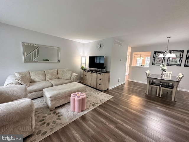 living room featuring visible vents, a chandelier, dark wood finished floors, and baseboards