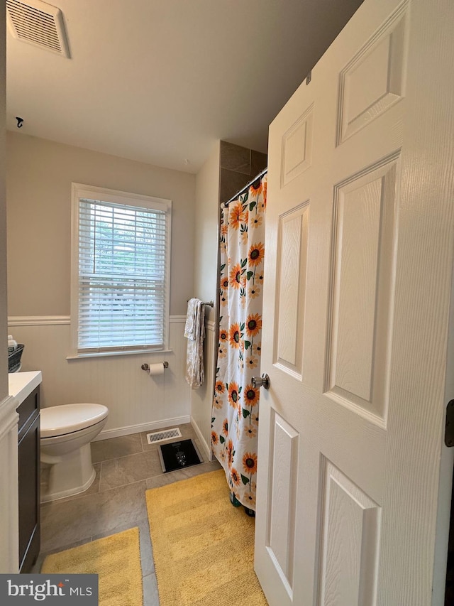 full bathroom with toilet, a wainscoted wall, visible vents, and vanity