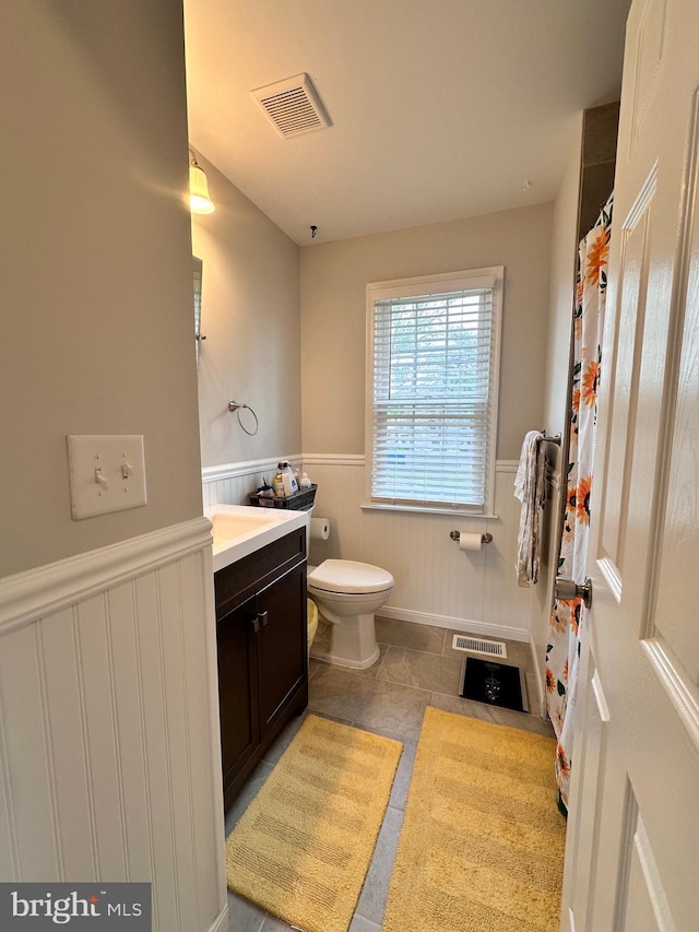 bathroom with tile patterned floors, a wainscoted wall, visible vents, and vanity