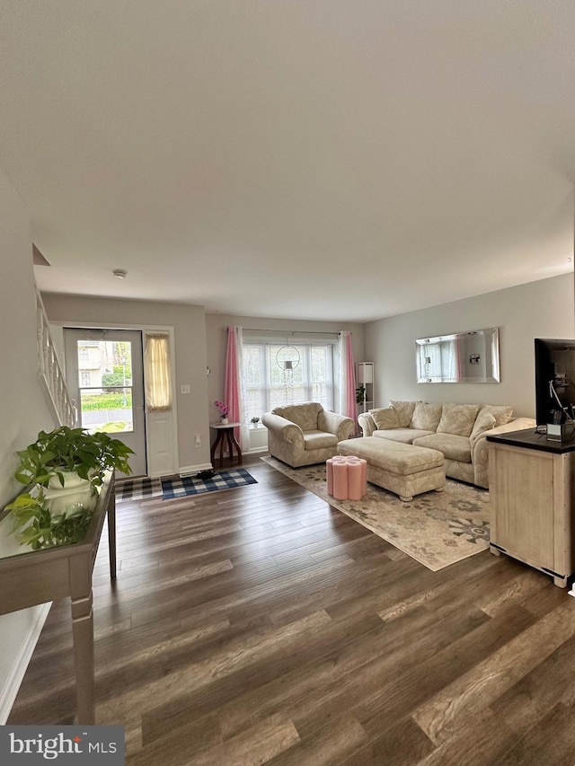living area featuring stairway, wood finished floors, and plenty of natural light