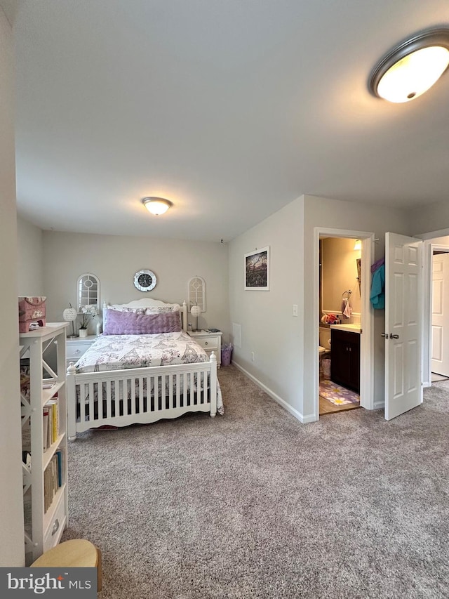 bedroom featuring ensuite bath, carpet floors, and baseboards