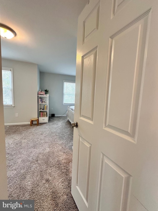 hallway with carpet and baseboards