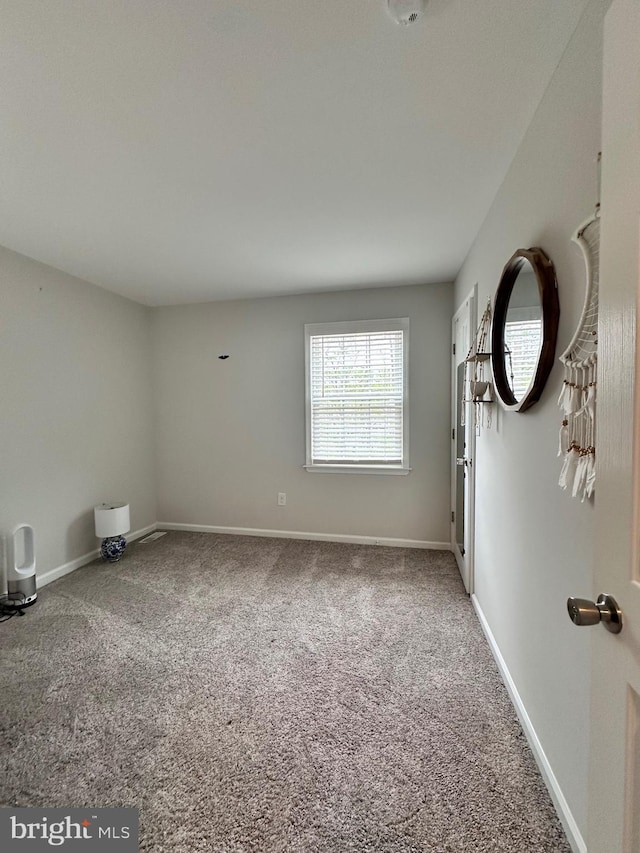 empty room featuring baseboards and carpet floors