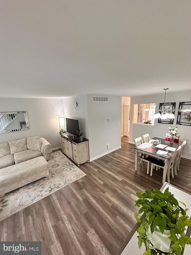 living area with visible vents, baseboards, and dark wood-type flooring
