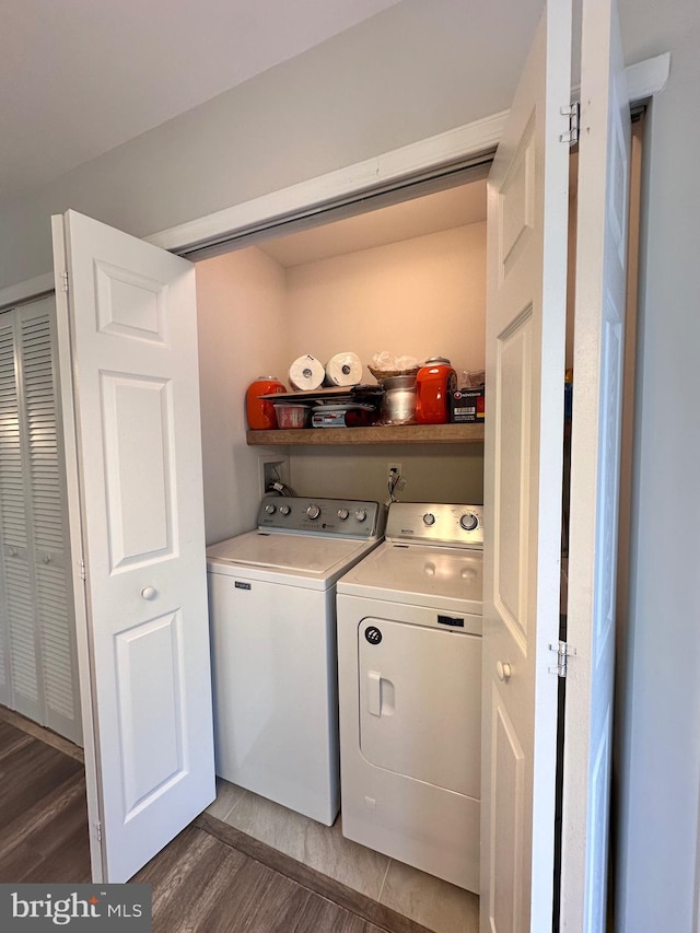 laundry room with wood finished floors, independent washer and dryer, and laundry area