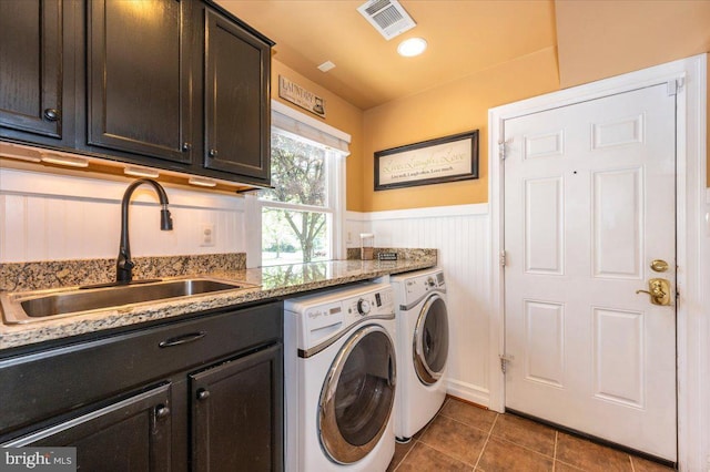 8412 Dasher Ct, Gaithersburg, MD 20882 - laundry area featuring washing machine and dryer, a wainscoted wall, cabinet space, and dark tile patterned flooring