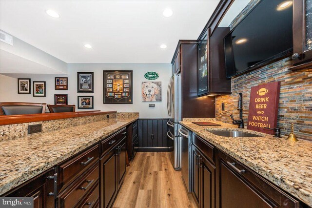 8412 Dasher Ct, Gaithersburg, MD 20882 - kitchen featuring a sink, appliances with stainless steel finishes, light wood-style flooring, light stone counters, and backsplash