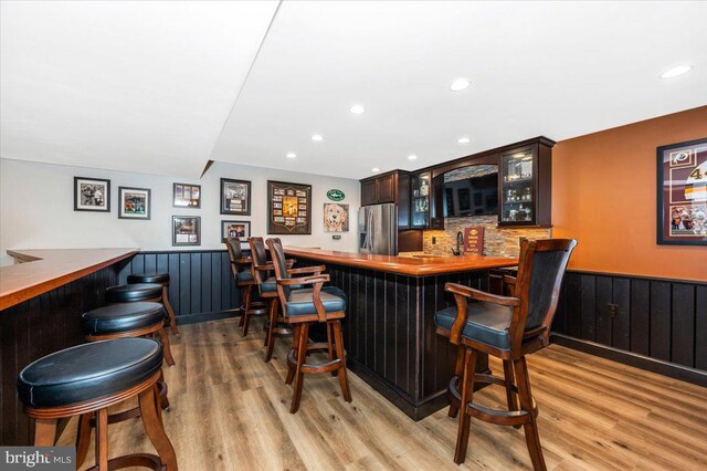 8412 Dasher Ct, Gaithersburg, MD 20882 - indoor bar featuring stainless steel fridge with ice dispenser, a wainscoted wall, light wood-type flooring, recessed lighting, and decorative backsplash