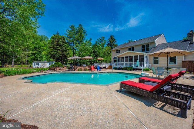 8412 Dasher Ct, Gaithersburg, MD 20882 - outdoor pool with a patio, a sunroom, an outdoor structure, a storage unit, and fence