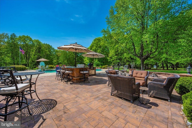 8412 Dasher Ct, Gaithersburg, MD 20882 - view of patio featuring an outdoor pool, an outdoor living space, and view of wooded area