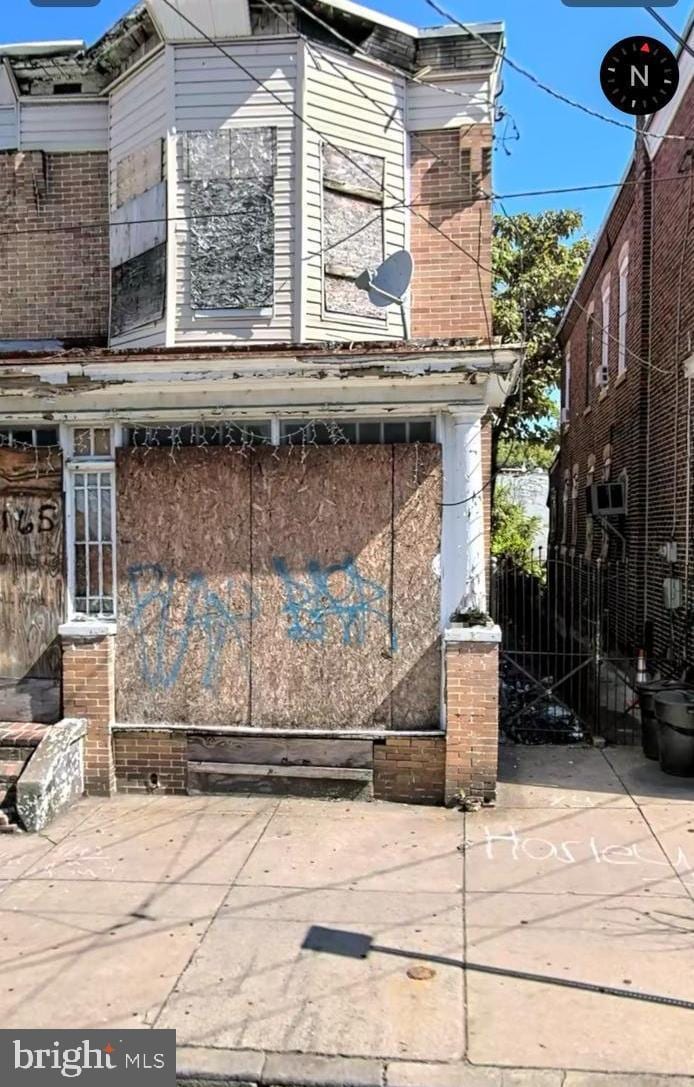 view of property exterior featuring brick siding and fence