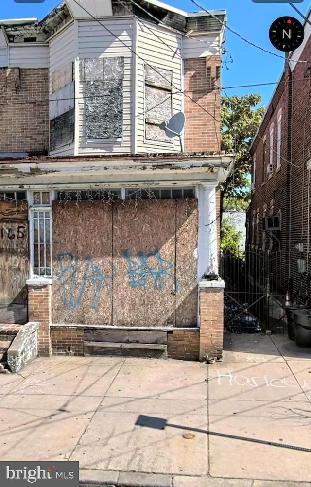 view of property exterior featuring brick siding and fence