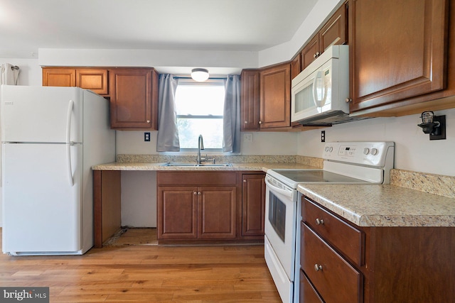 1722 Antler Ln, Finksburg, MD 21048 - kitchen featuring white appliances, a sink, light countertops, light wood-type flooring, and brown cabinetry