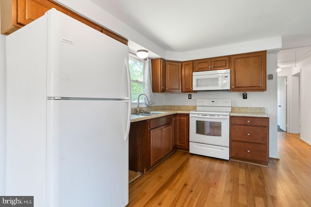 1722 Antler Ln, Finksburg, MD 21048 - kitchen with white appliances, a sink, light wood-style floors, light countertops, and brown cabinetry