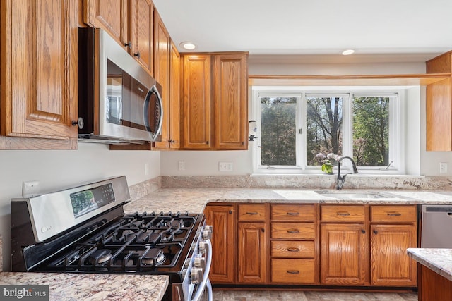 8519 Century Oak Ct, Fairfax Station, VA 22039 - kitchen with stainless steel appliances, light stone countertops, brown cabinetry, and a sink
