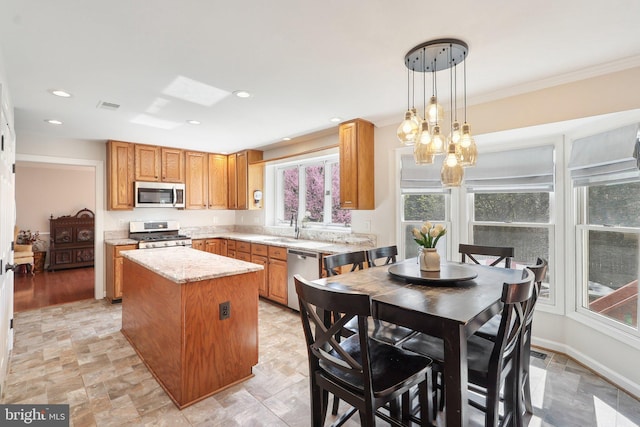 8519 Century Oak Ct, Fairfax Station, VA 22039 - kitchen featuring ornamental molding, a kitchen island, visible vents, appliances with stainless steel finishes, and pendant lighting