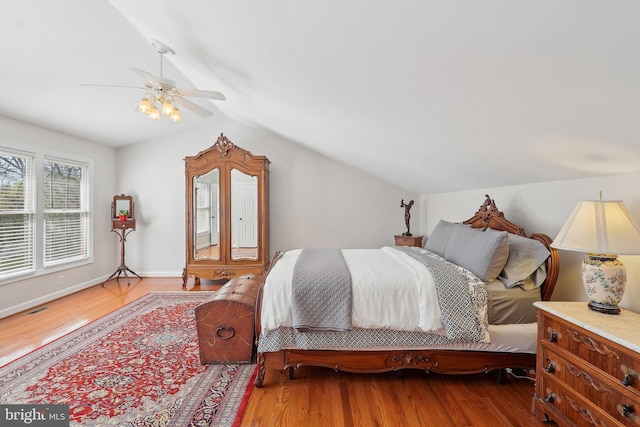 8519 Century Oak Ct, Fairfax Station, VA 22039 - bedroom featuring a ceiling fan, visible vents, vaulted ceiling, wood finished floors, and baseboards