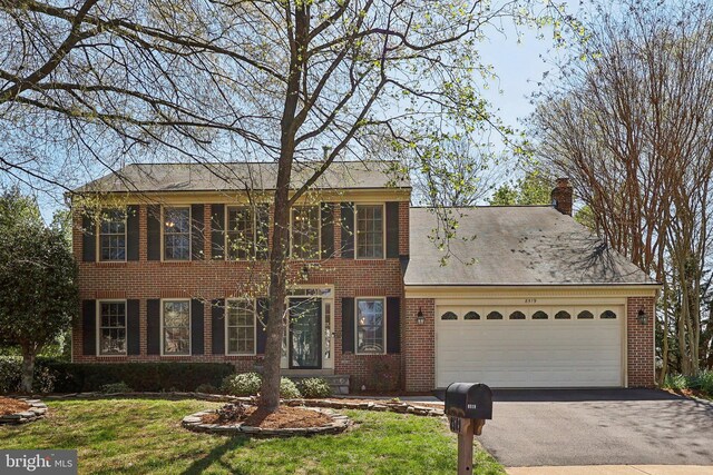 8519 Century Oak Ct, Fairfax Station, VA 22039 - colonial-style house featuring aphalt driveway, a front lawn, brick siding, a chimney, and a garage