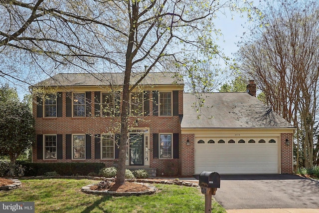 8519 Century Oak Ct, Fairfax Station, VA 22039 - colonial inspired home with an attached garage, a chimney, aphalt driveway, brick siding, and a front lawn
