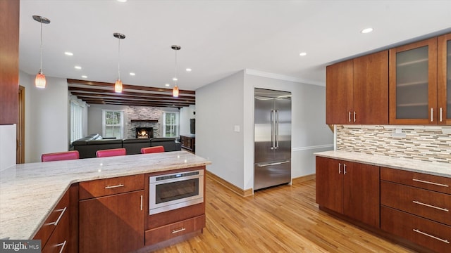 115 Union Mill Ter, Mount Laurel, NJ 08054 - kitchen with decorative light fixtures, a stone fireplace, built in fridge, backsplash, and light wood-style flooring