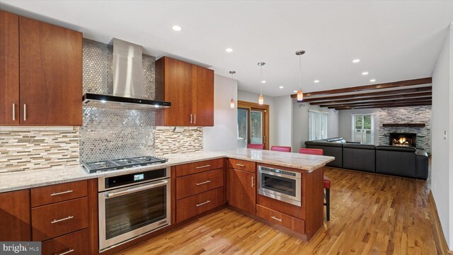 115 Union Mill Ter, Mount Laurel, NJ 08054 - kitchen featuring stainless steel appliances, a peninsula, light wood-style flooring, and wall chimney exhaust hood