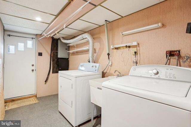 laundry area featuring washing machine and dryer, light colored carpet, and electric panel