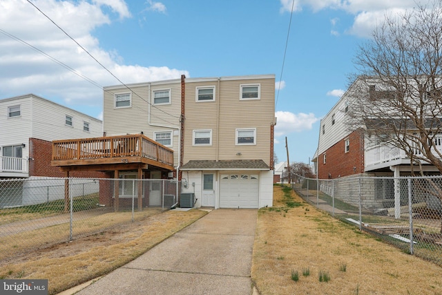 rear view of house featuring fence, a yard, an attached garage, and concrete driveway