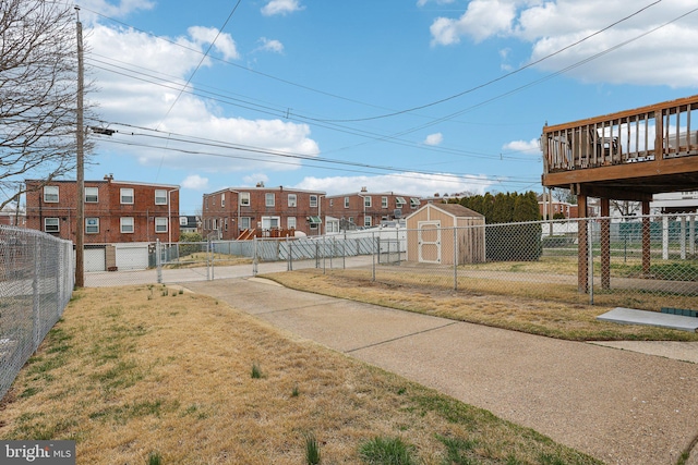 view of property's community featuring a fenced backyard, a storage unit, an outdoor structure, and a yard