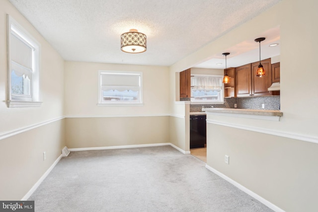 kitchen with light carpet, tasteful backsplash, dishwasher, under cabinet range hood, and baseboards