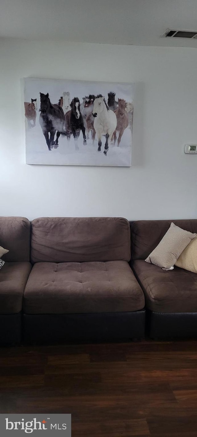 living room featuring visible vents and wood finished floors