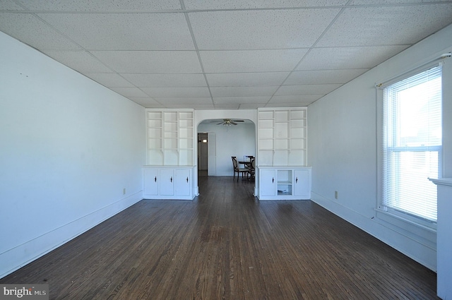 109 N Centre St, Philipsburg, PA 16866 - unfurnished living room featuring baseboards, a ceiling fan, arched walkways, dark wood-style floors, and a paneled ceiling
