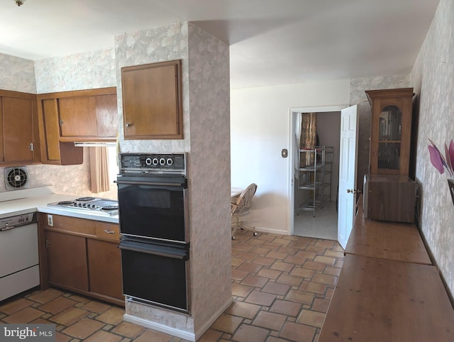 kitchen with oven, brown cabinets, dishwasher, stainless steel electric stovetop, and light countertops